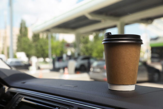 Paper,Coffee,Cup,On,Car,Dashboard,At,Gas,Station.,Space